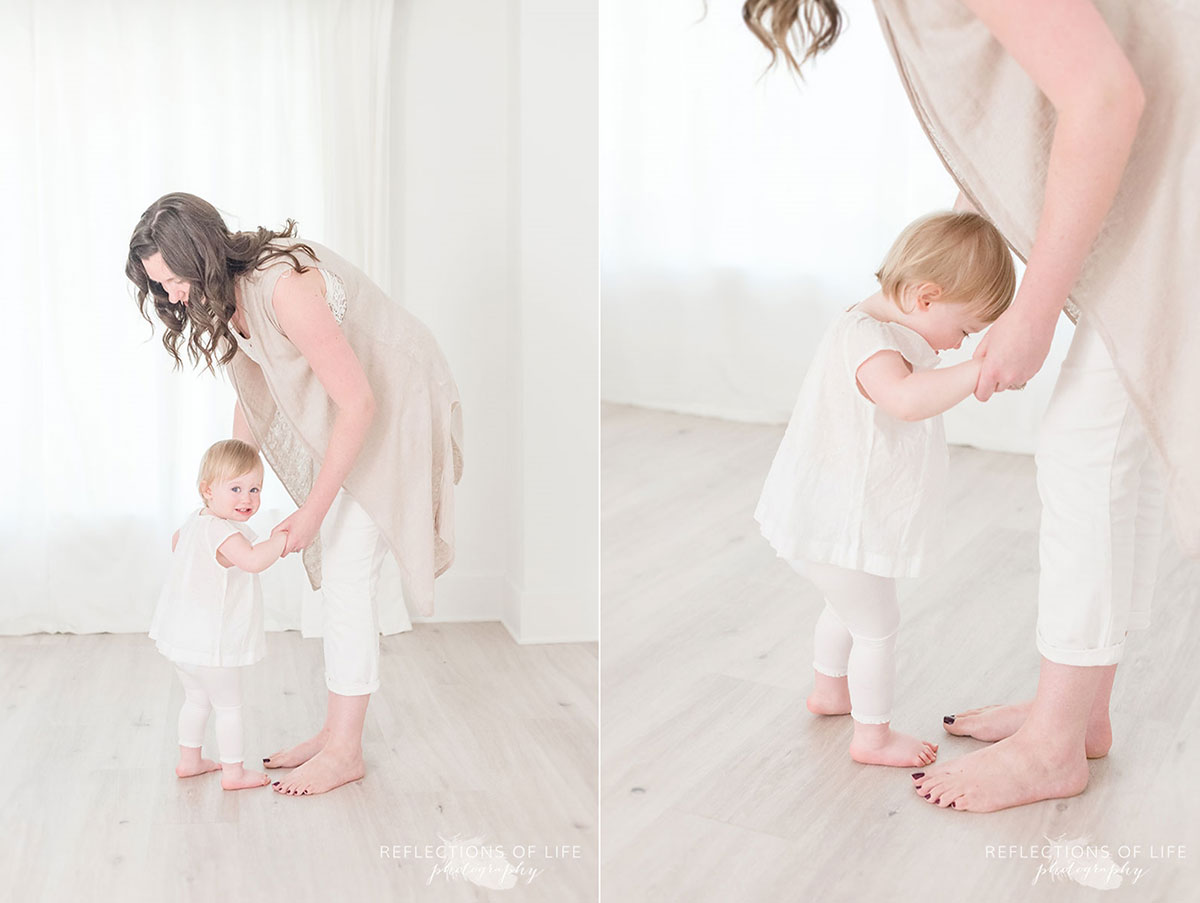 mom teaches one year old daughter to dance in the photo studio