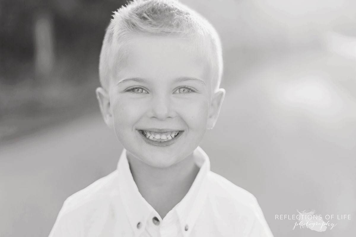 Little boy smiling at the camera in black and white