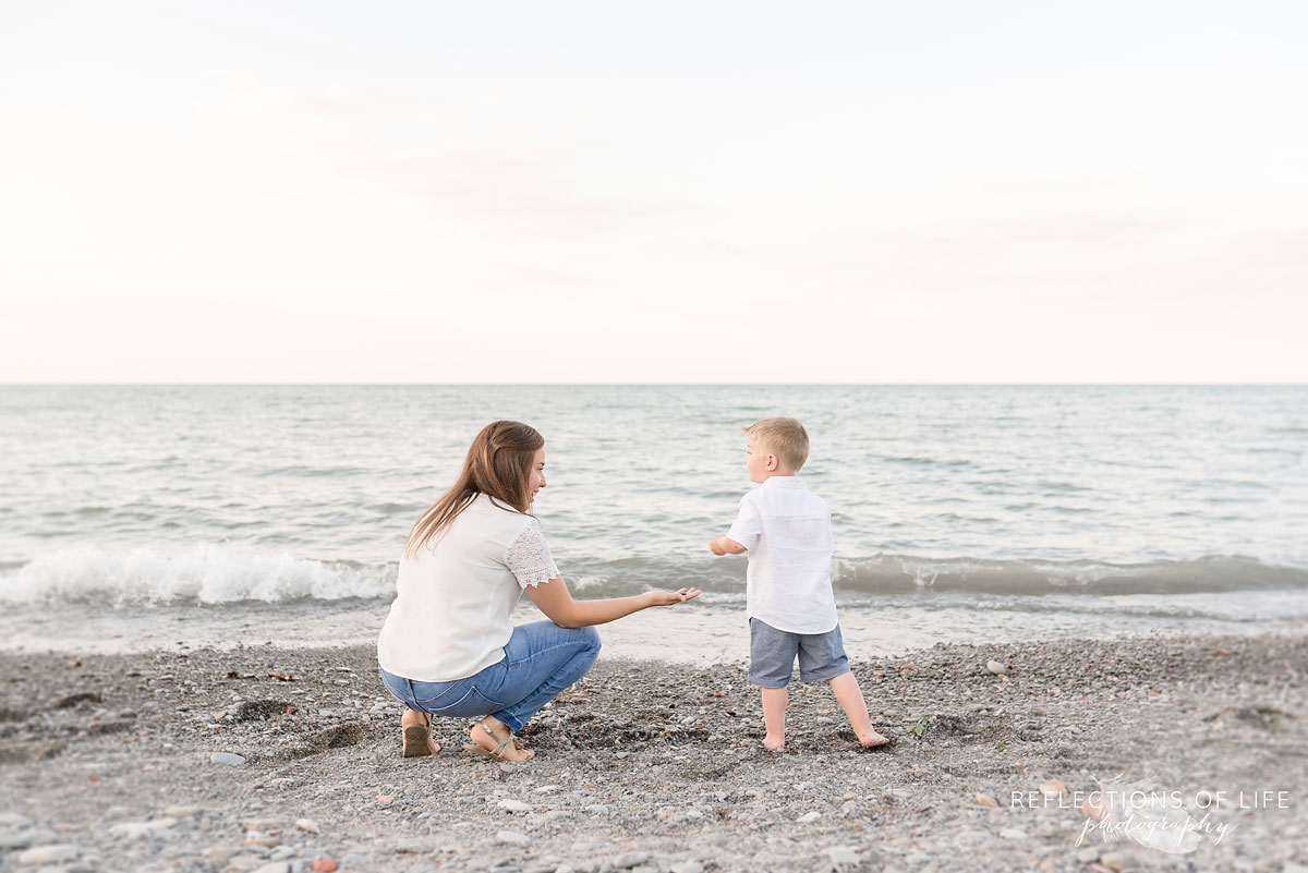 Mom handing her son a rock at Casablanca Beach in Grimsby