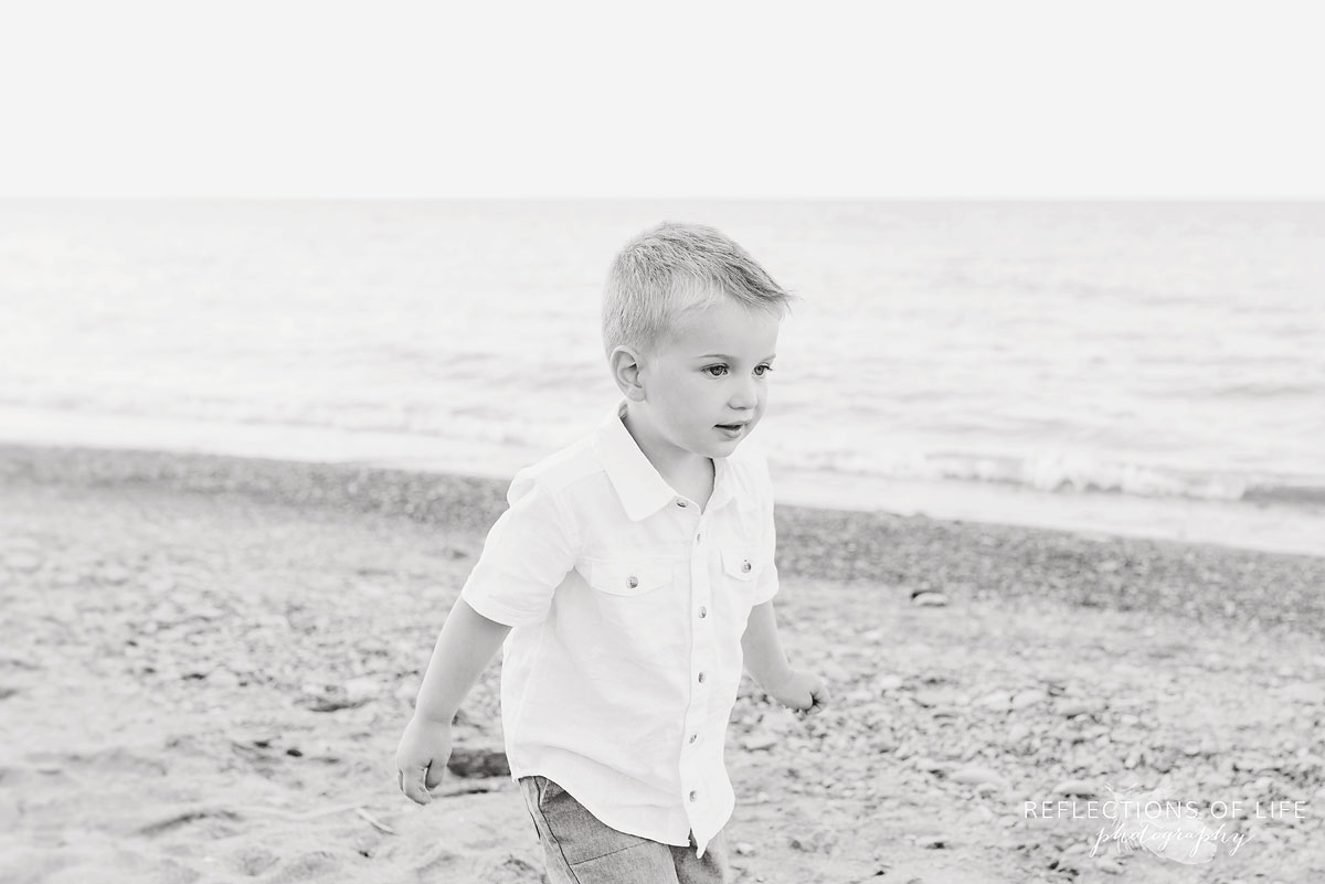 Little boy walking down the sandy beach