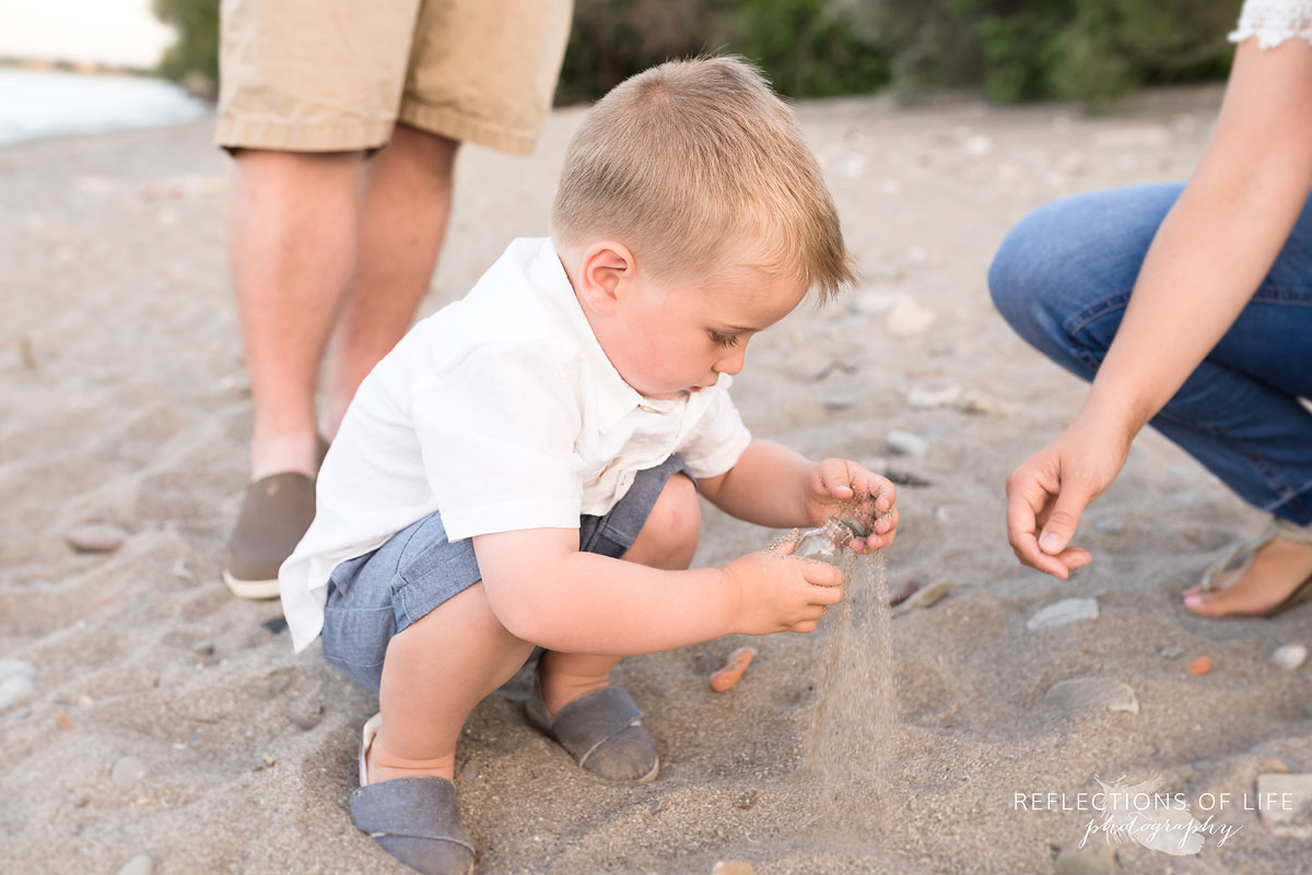 Little boy playing with sand at Grimsby Beach