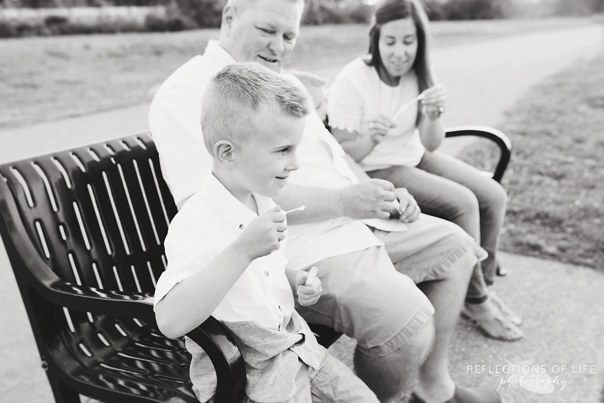 Niagara family photos of family blowing bubbles on the bench at Casablanca Beach