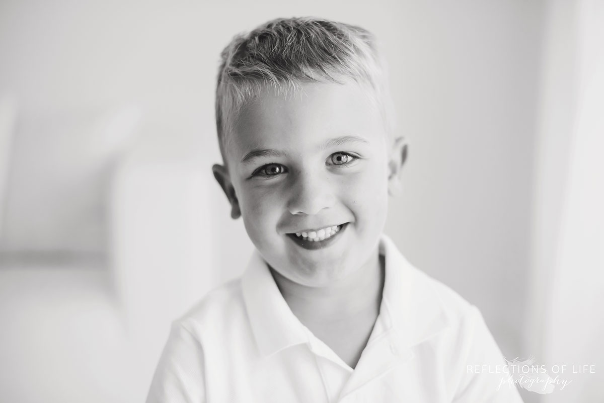 little boy smiling in black and white