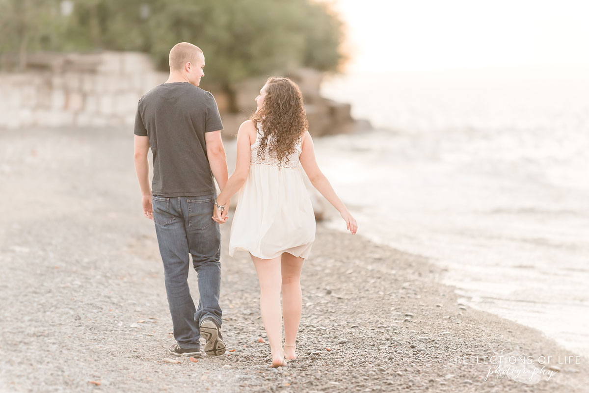 Girlfriend and boyfriend walking along the beach holding hands