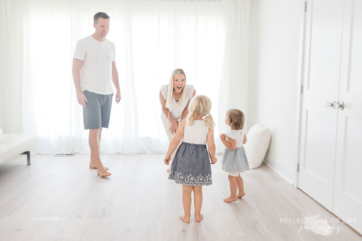 Family of four playing in white studio