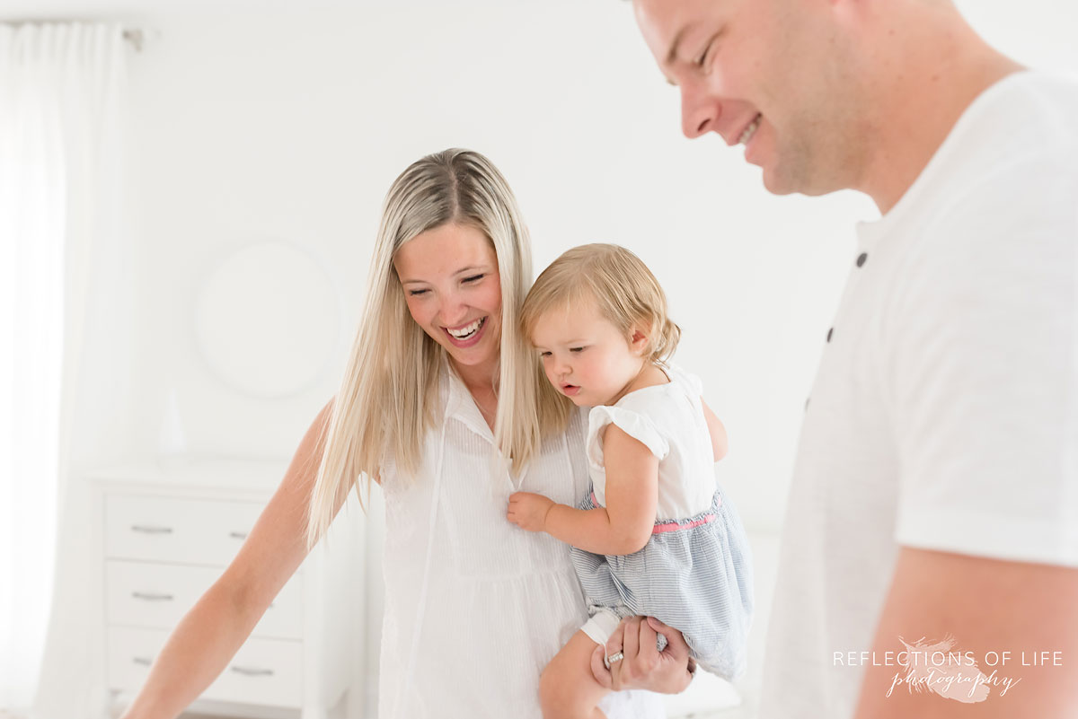 father mother and daughter in white studio Grimsby Ontario