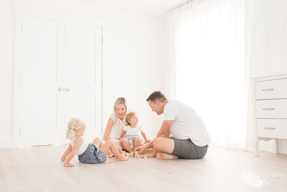 family playing in white studio