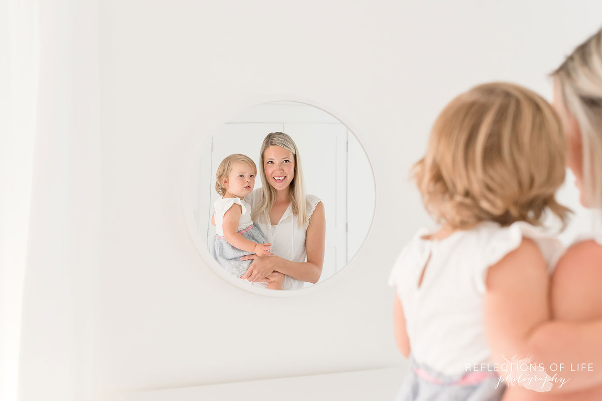 mom and daughter looking into mirror