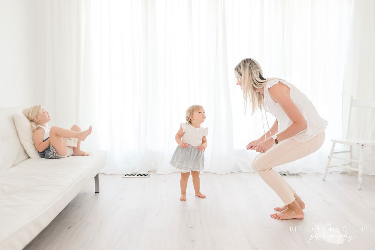 mom and daughters dancing in white studio
