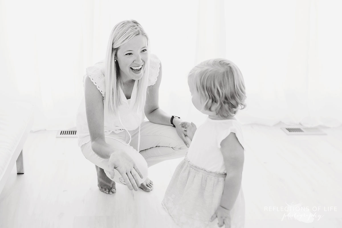 black and white of mom opening her arms to daughter