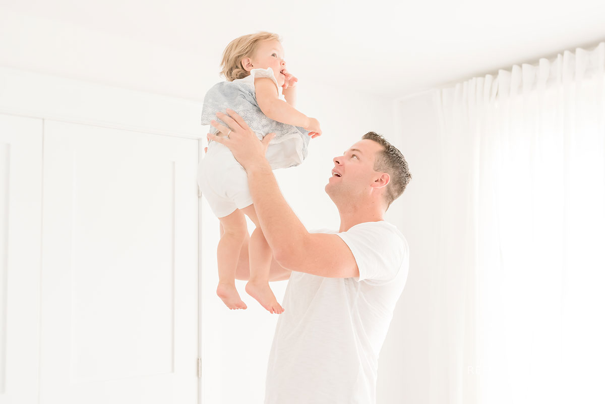 dad holding baby up high