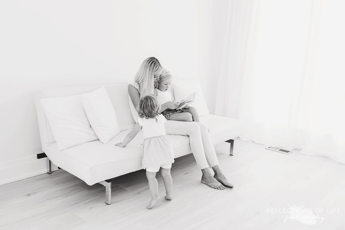 black and white of mom and daughters reading a book