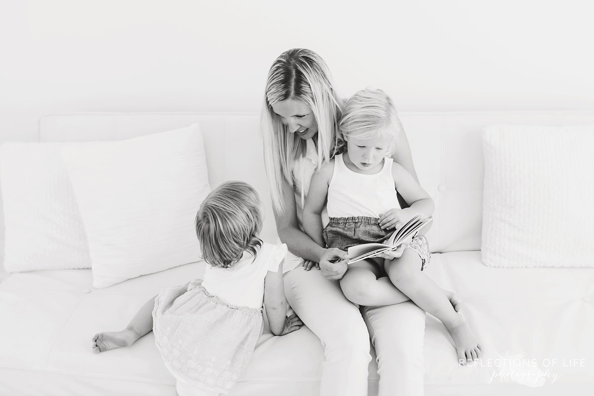 black and white of mom reading a story to kids