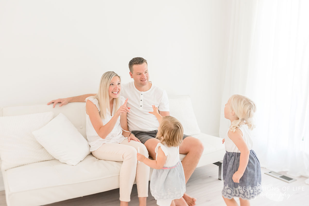 family playing on white couch