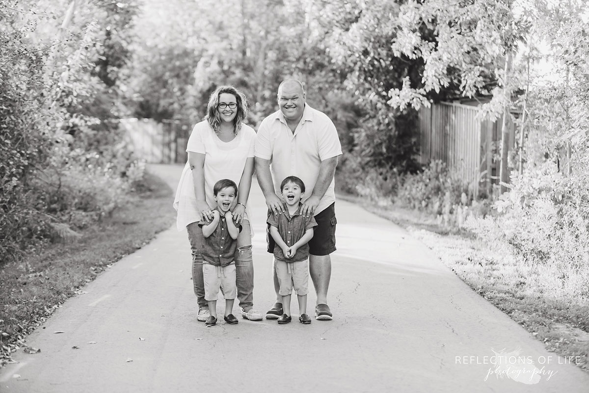 Family of four laughing on a path in Grimsby, Ontario black and white