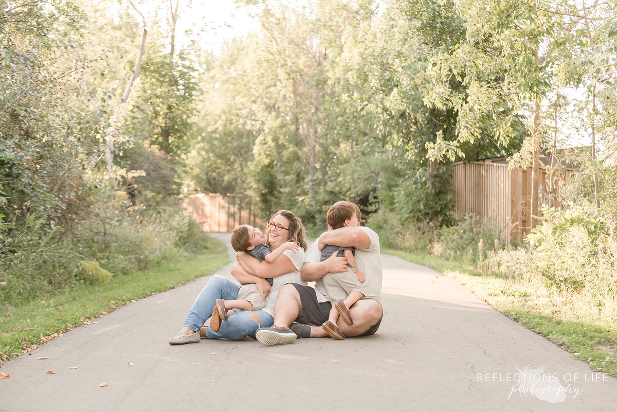 Family of four sat on a path hugging