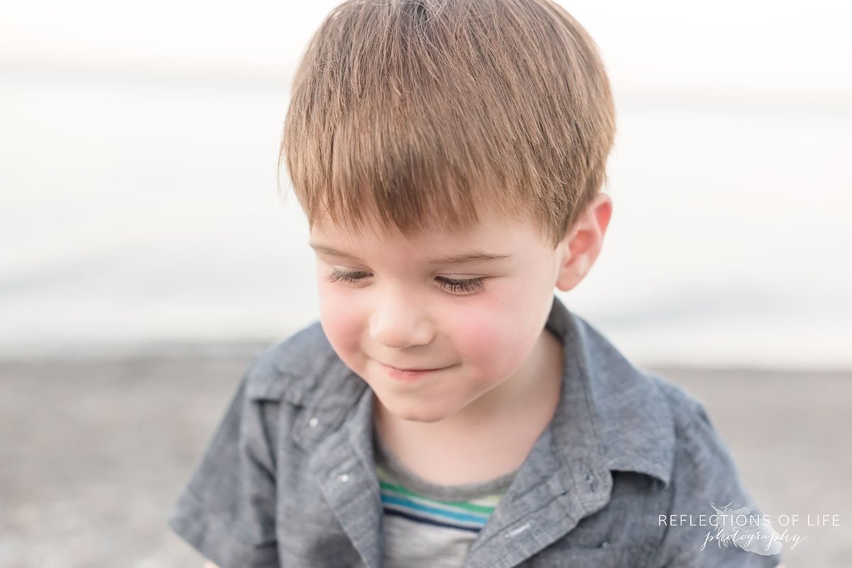 young boy looking down and smiling