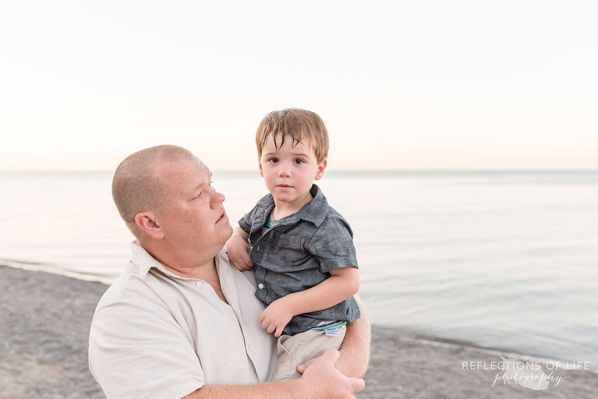 a dad holding his son on Grimsby Beach in Ontario