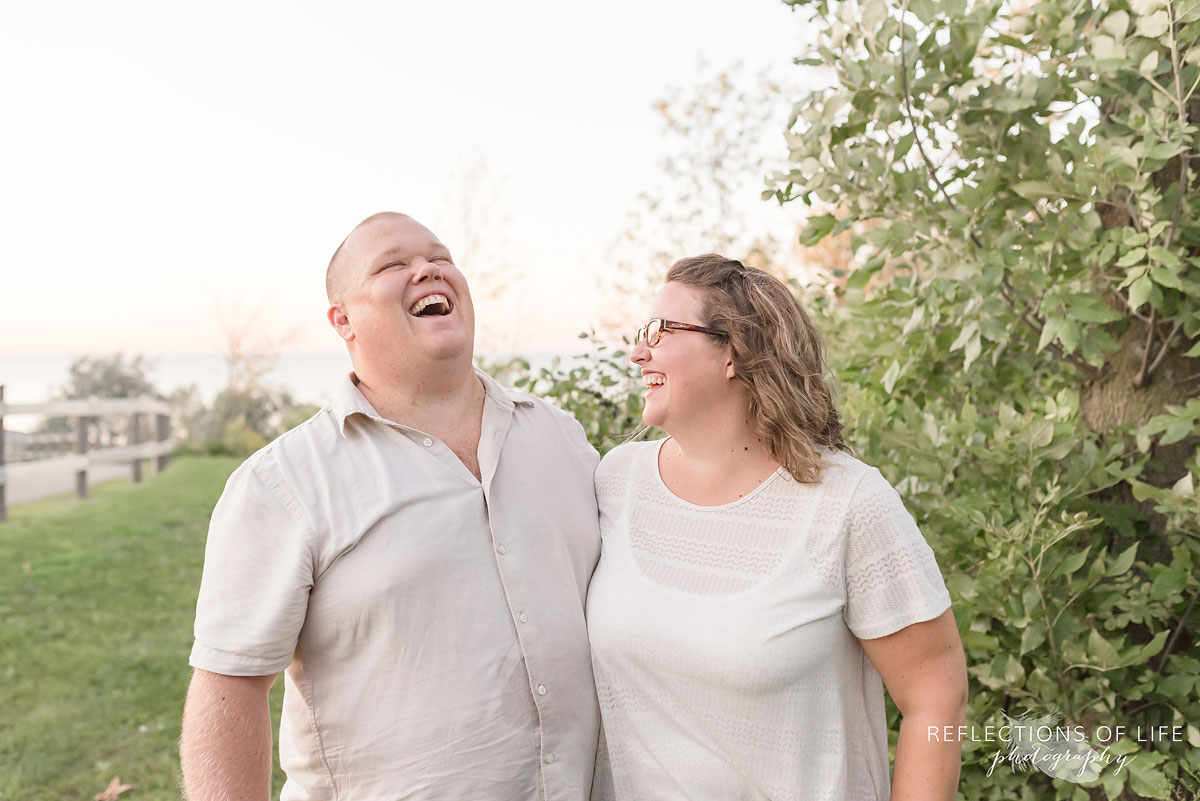 happy parents laughing near shrubbery