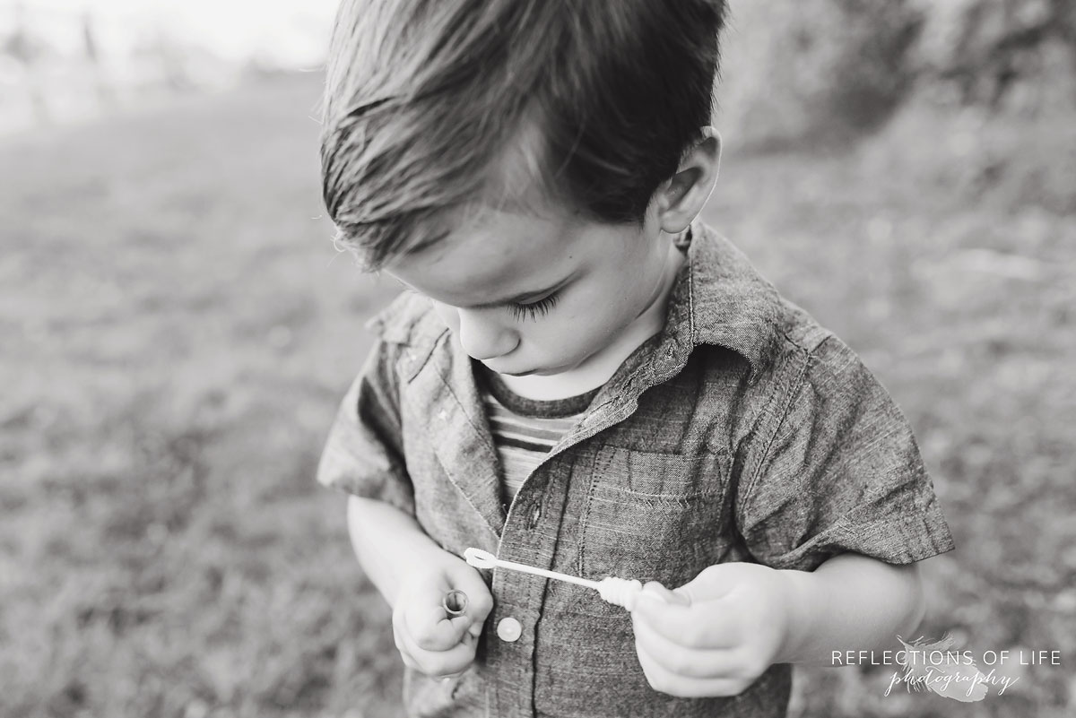 Young boy playing with bubbles black and white