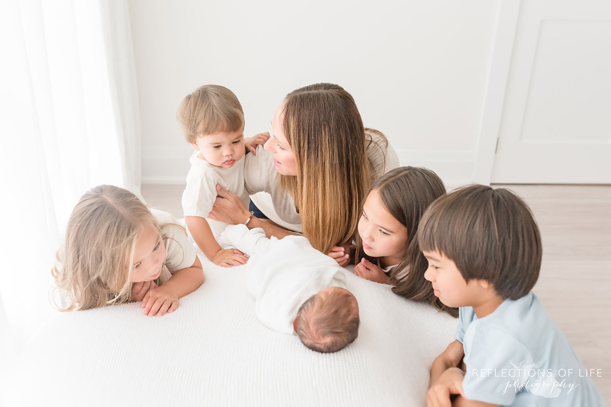 four children and their mom looking at their new sibling