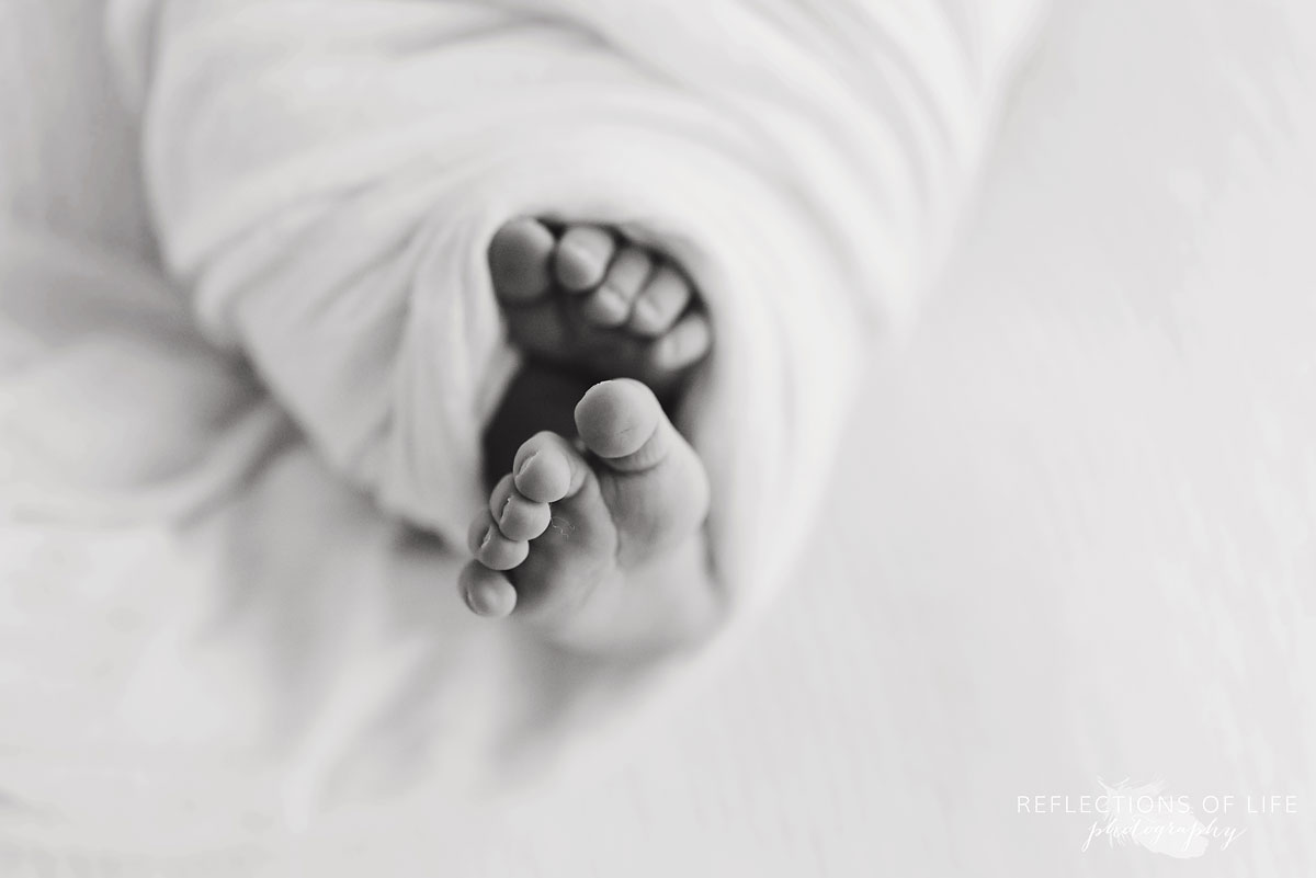baby toes that are swaddled in a blanket by Karen Byker black and white