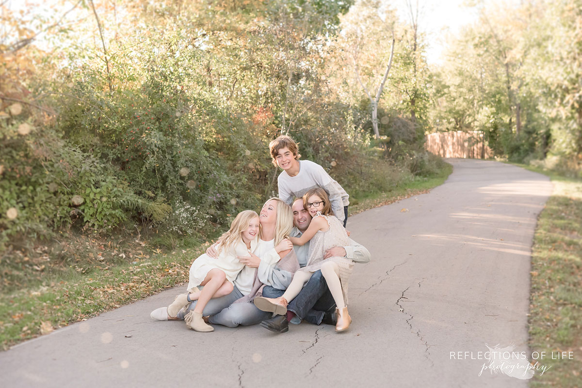 Family of five laughing on walkway