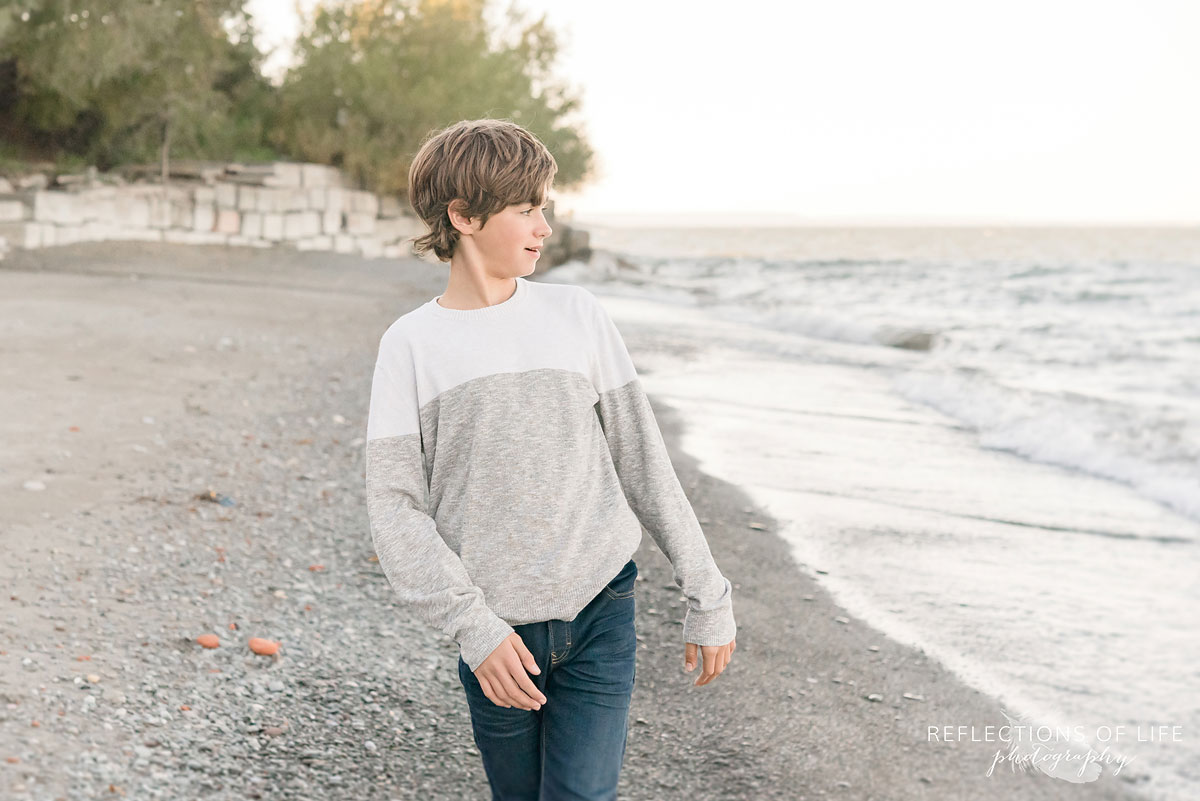 boy looking at beach after throwing rocks into water