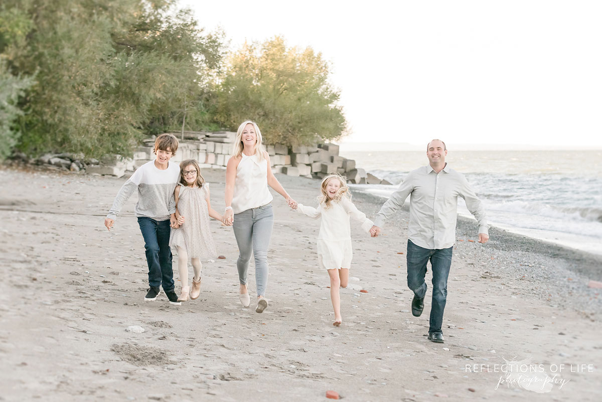 family holding hands running on beach