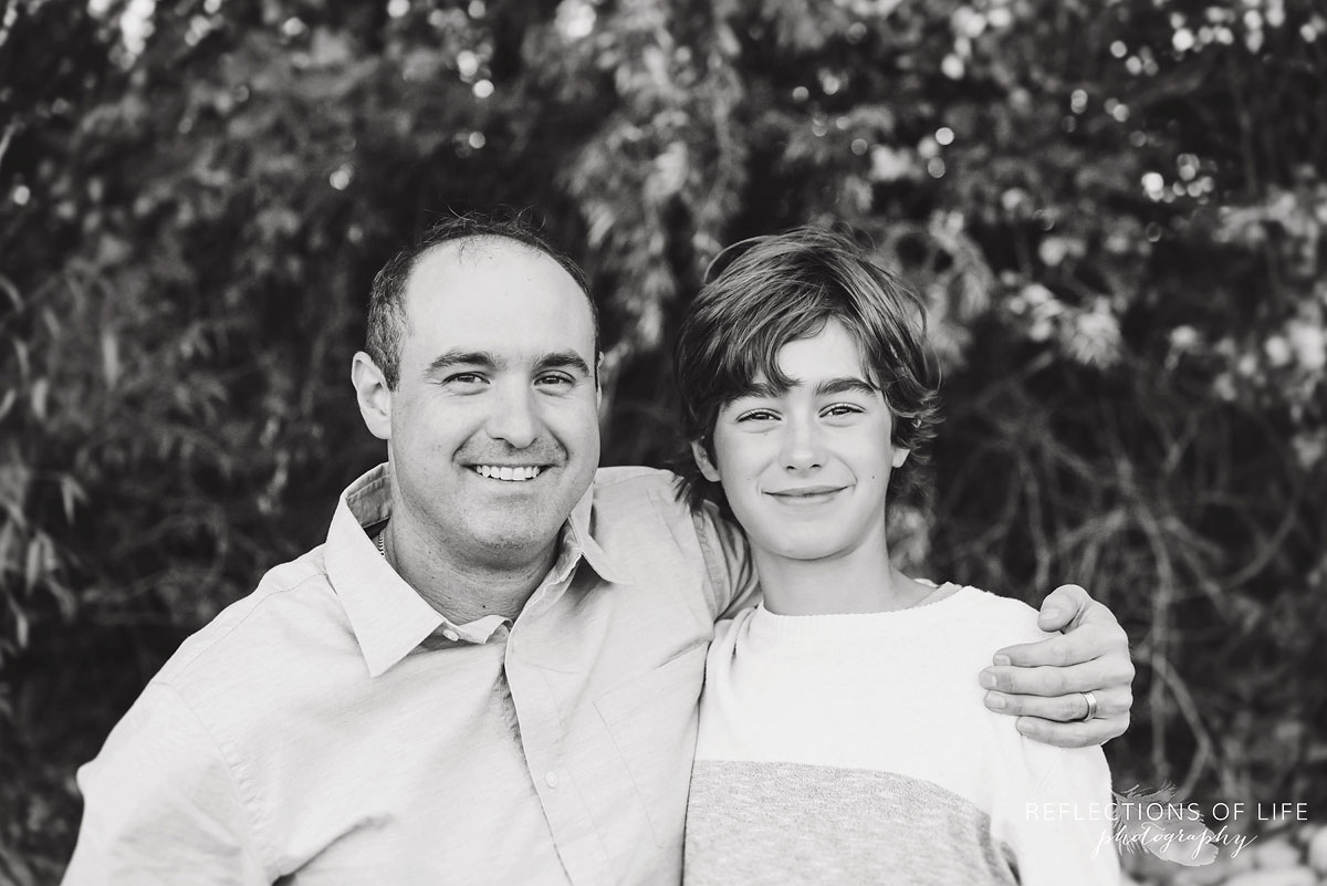 black and white of father with arm around son