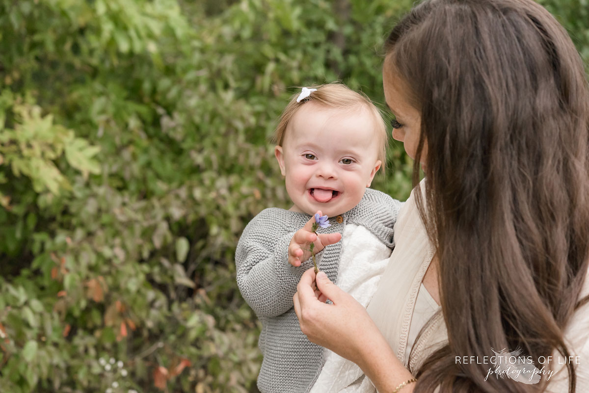 001 mother holding a flower in front of baby