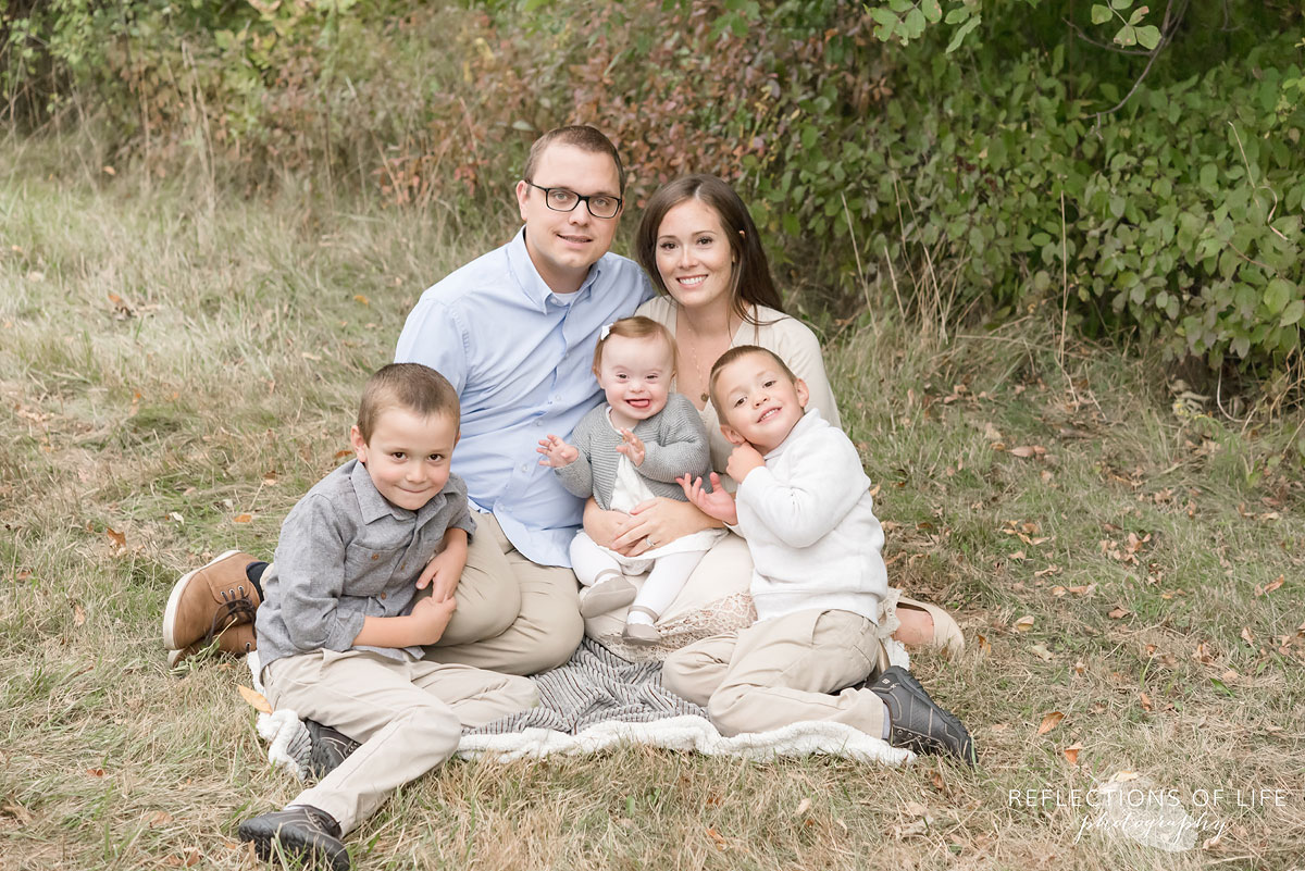 006 family sitting in field smiling at camera