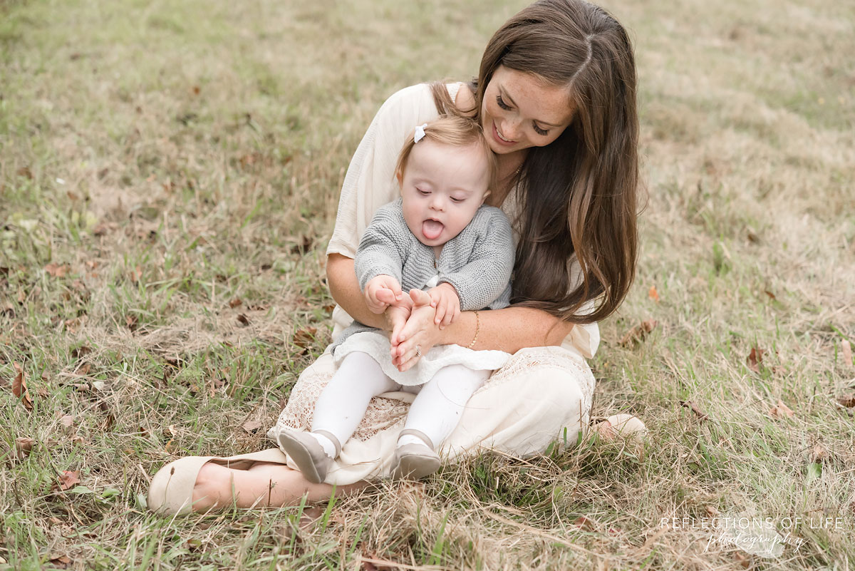 030 baby sitting on mamas lap in field