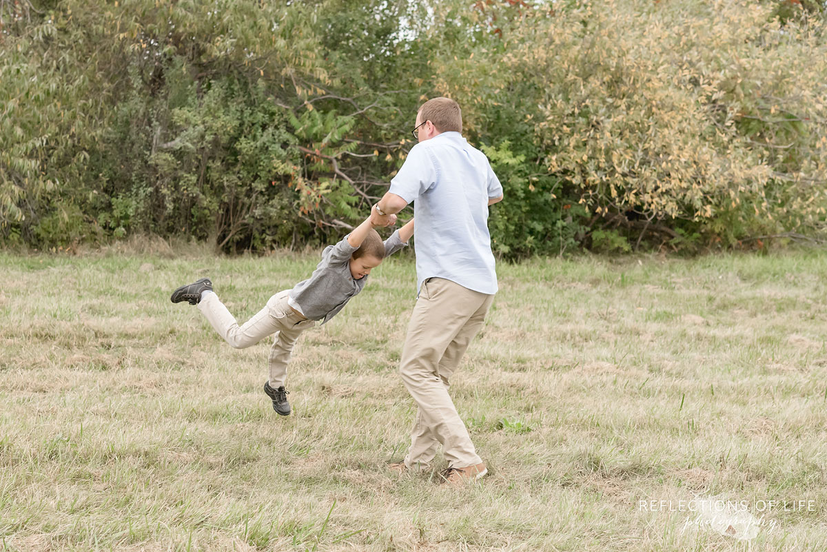 032 father swinging son in field