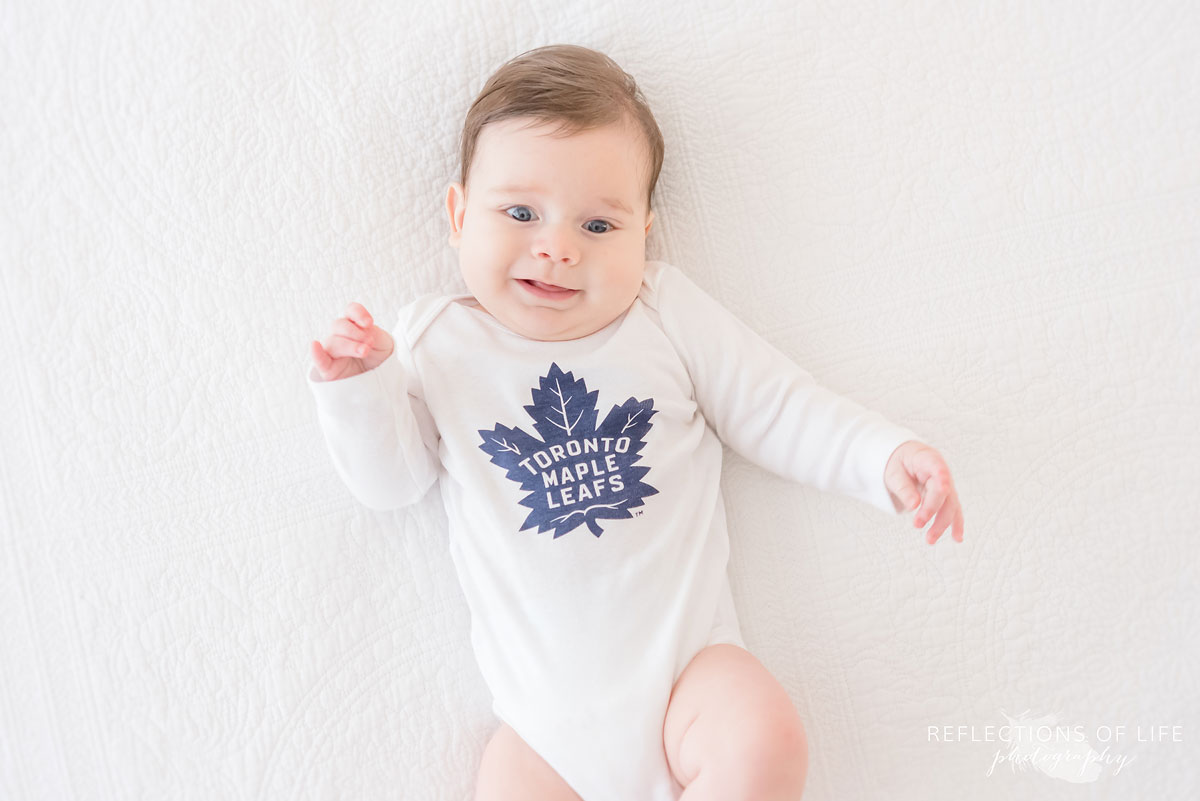 baby with toronto maple leaf onesie