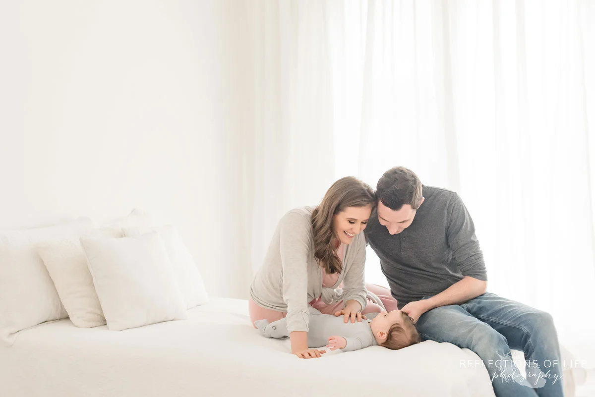 family smiling at baby in newborn studio.jpg
