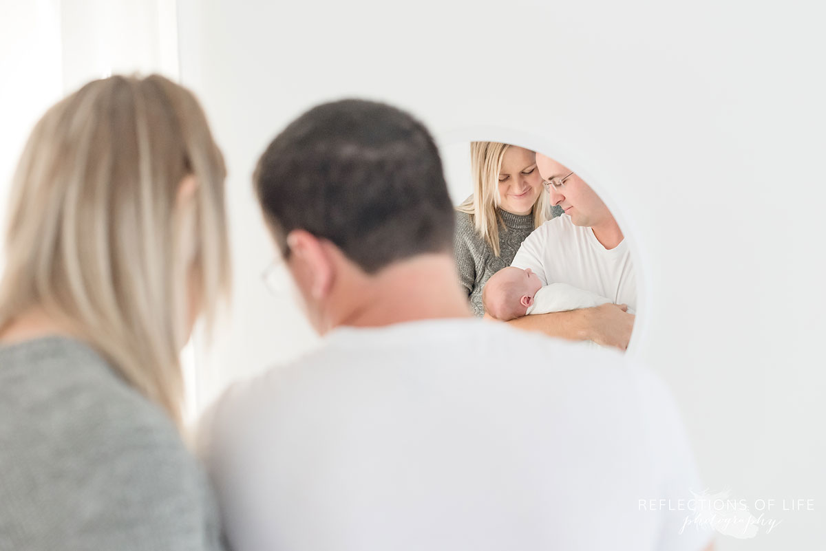 mother father and baby in white mirror