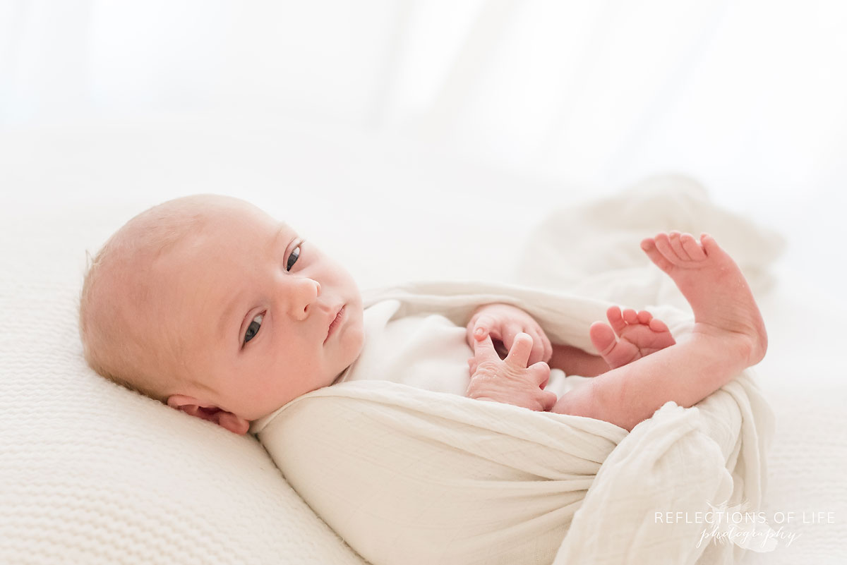 baby wrapped in white clothq