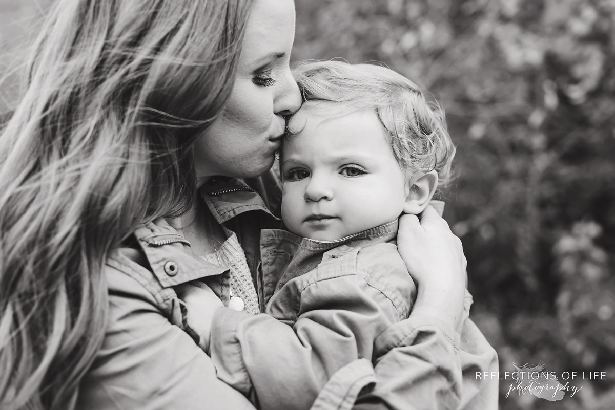 mothing kissing her child black and white