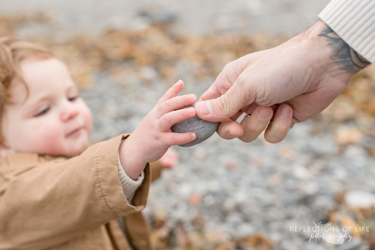 dad handing child a rock