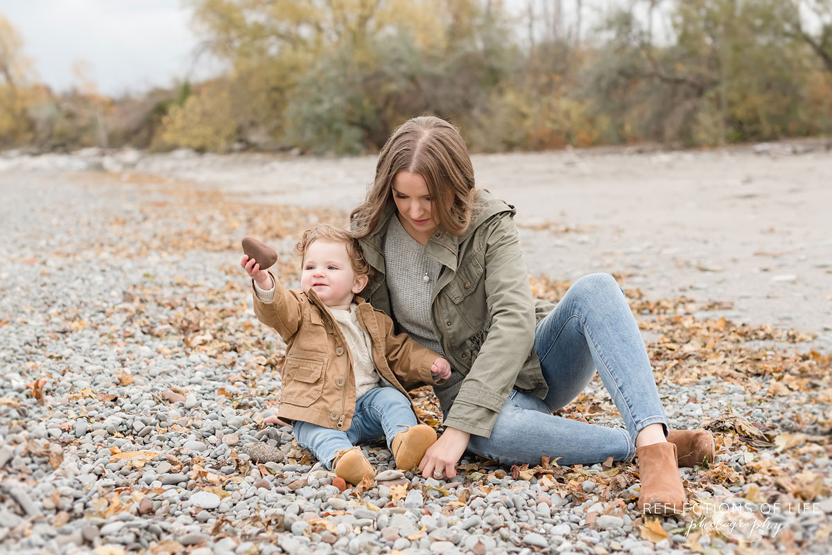 mother and child looking at rocks on the beach