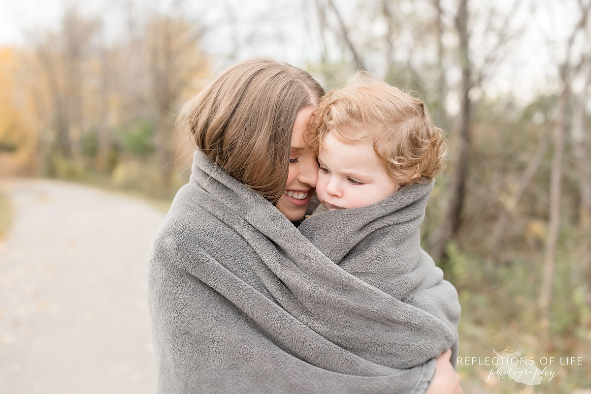 mother and child cuddling in a blanket