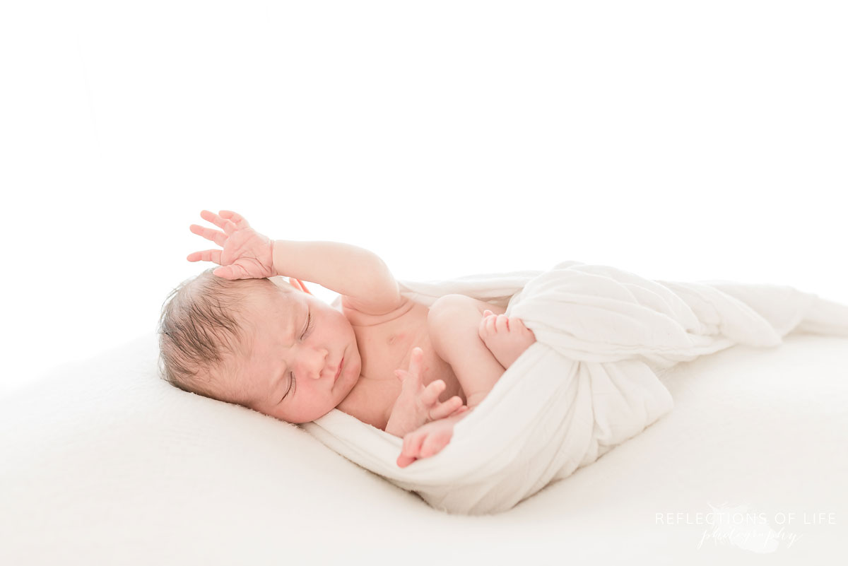 newborn raising hand up