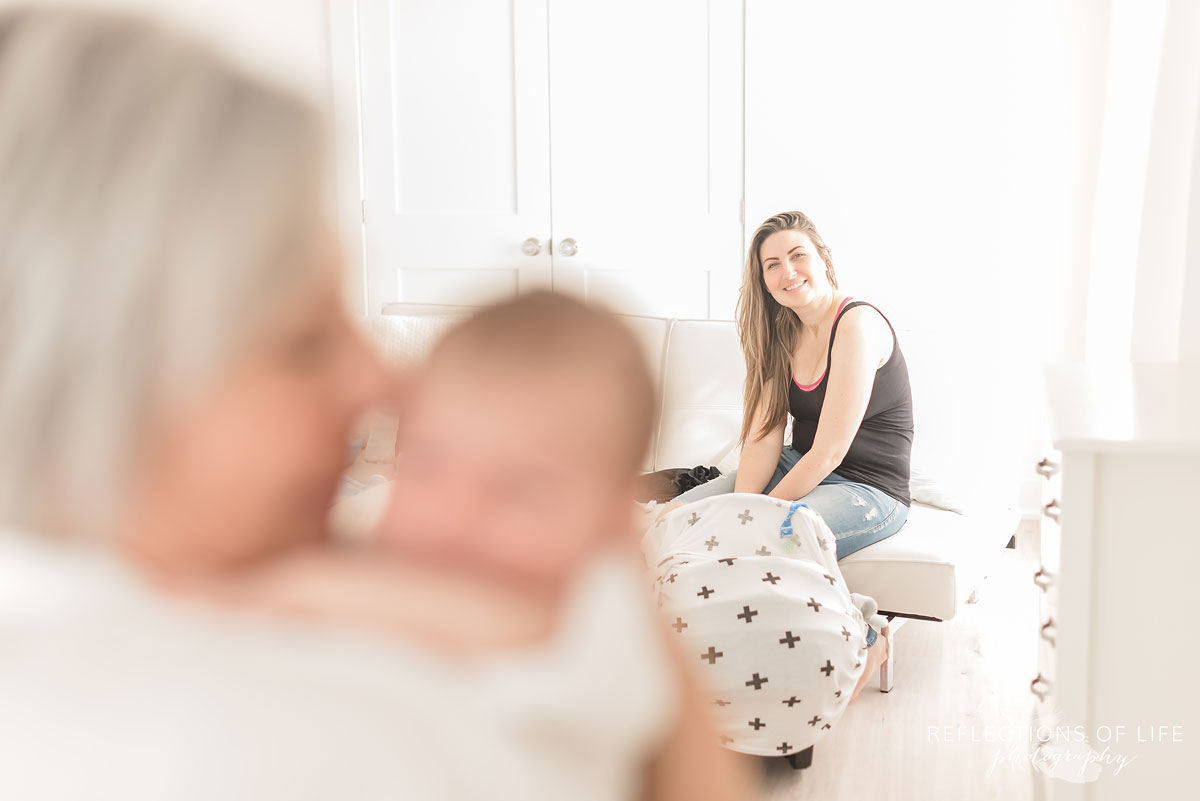 mama watching grandma and newborn