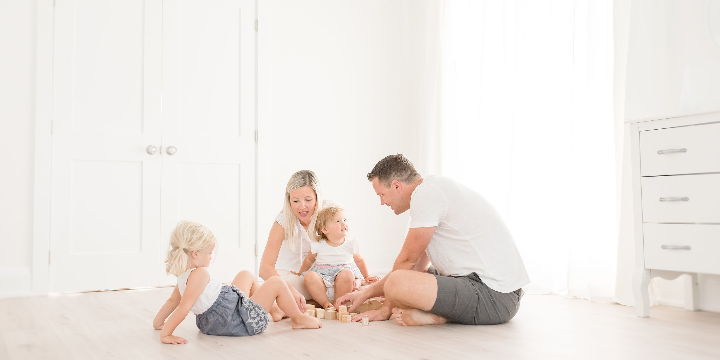 Family playing with blocks in white studio