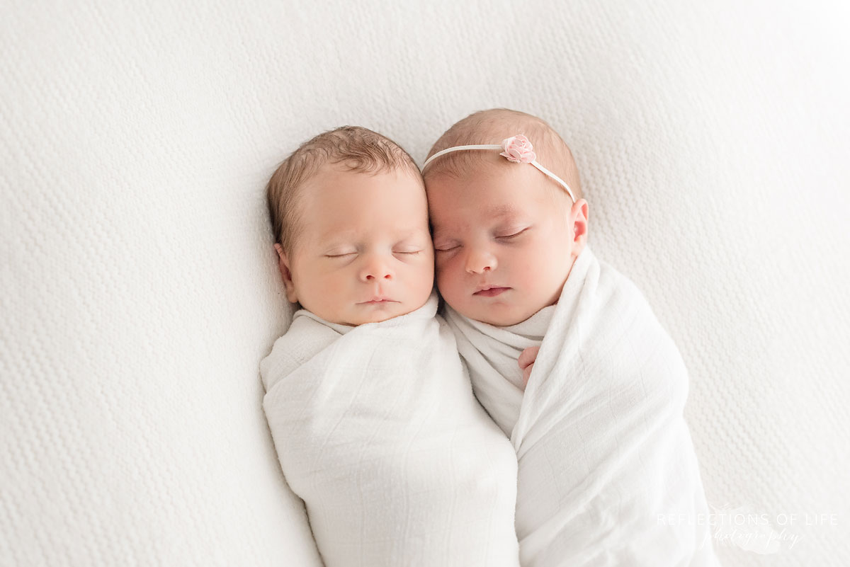 twin newborns on white blanket