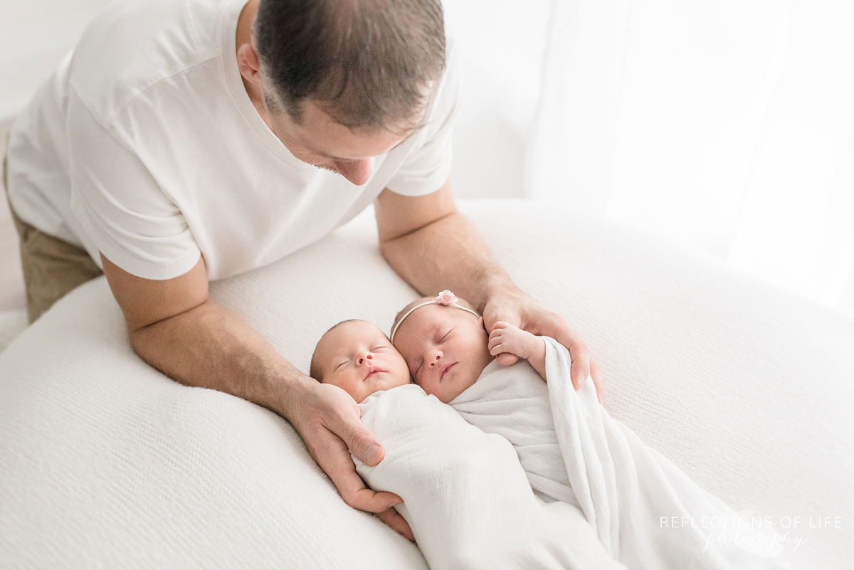 father looking at newborns