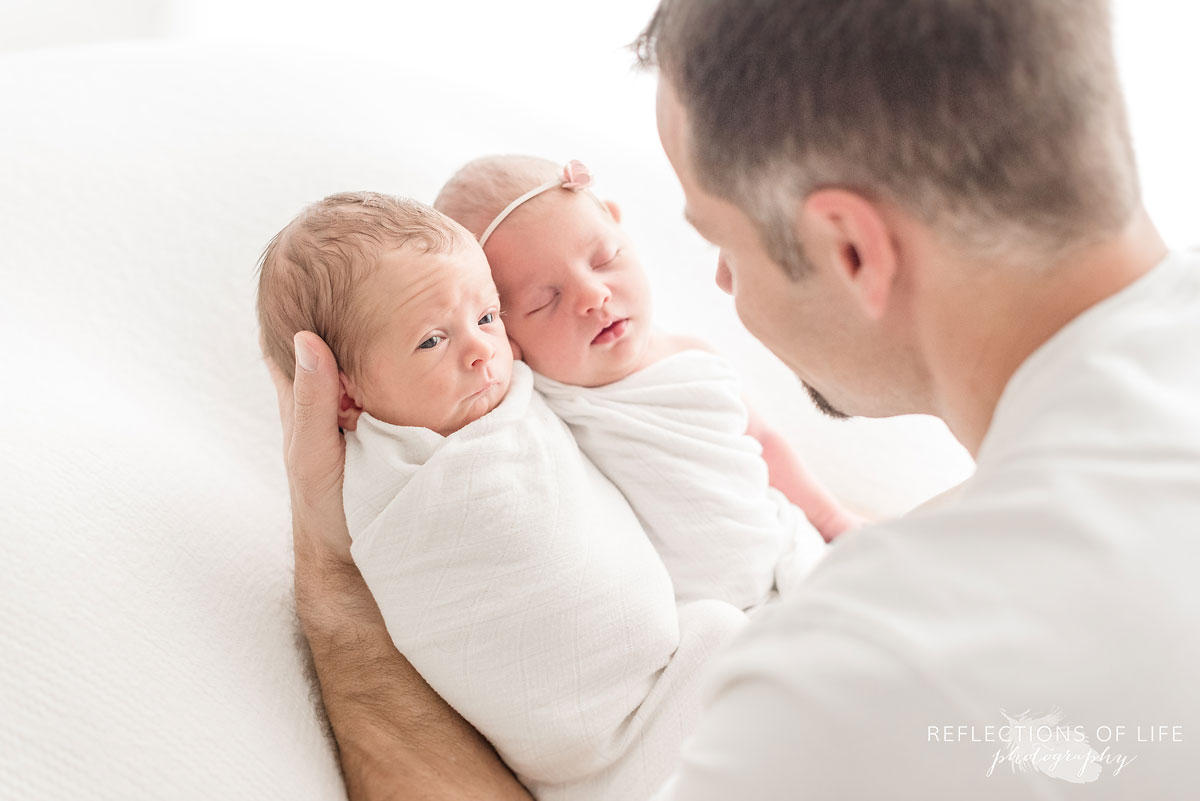 father holding his newborns in white studio grimsby