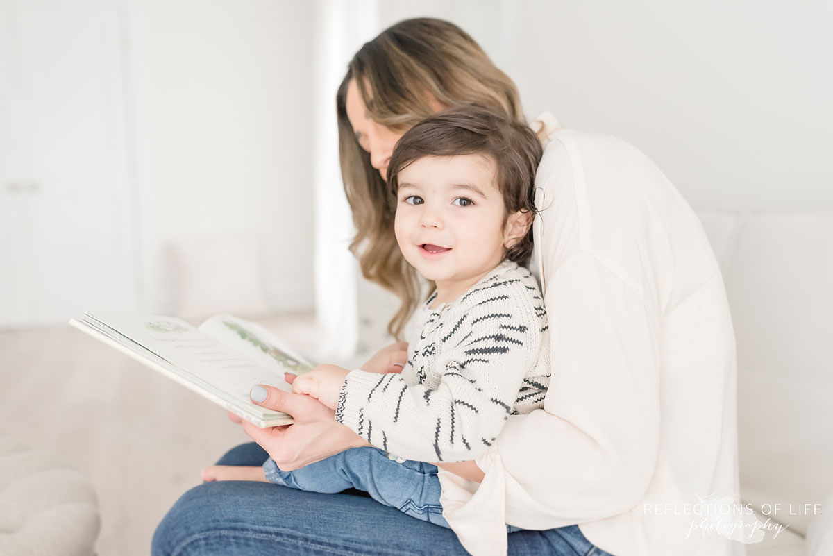 son smiling at camera while reading
