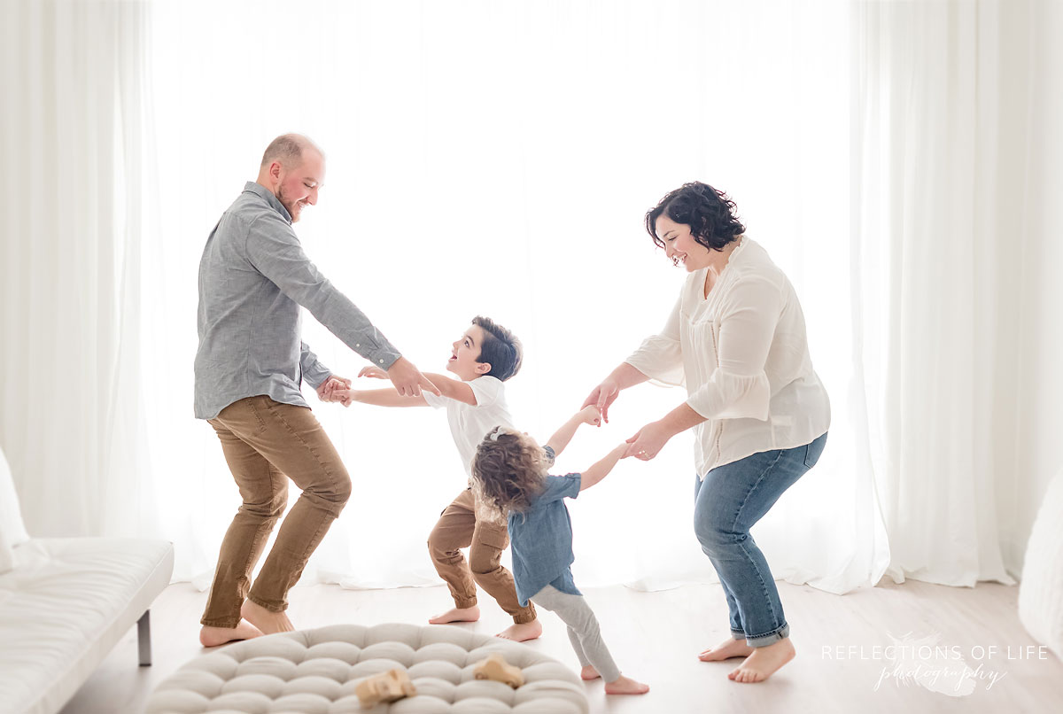 Family dancing in white studio
